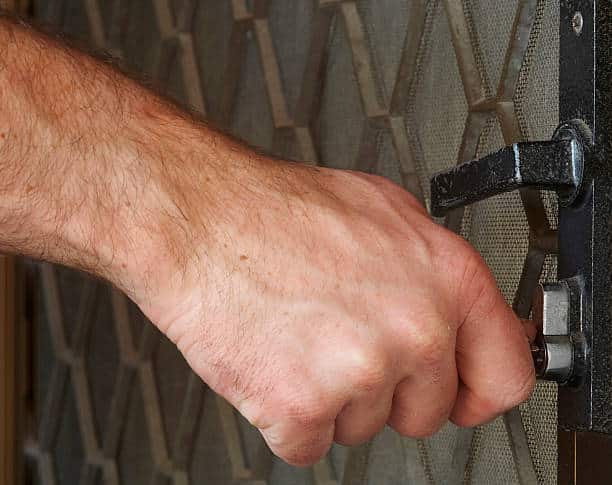 A hand unlocking a door
