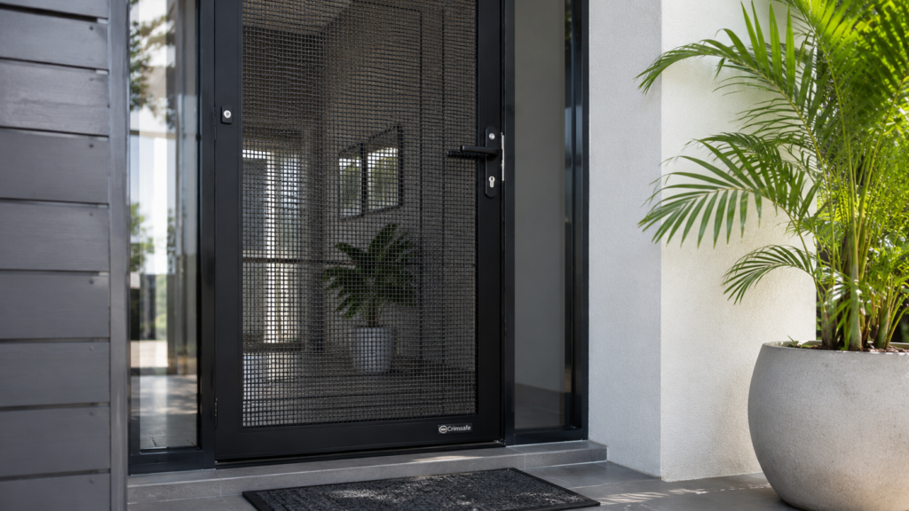 Hinged Crimsafe Security Door With Reinforced Mesh And Lock At A Front Entrance.
